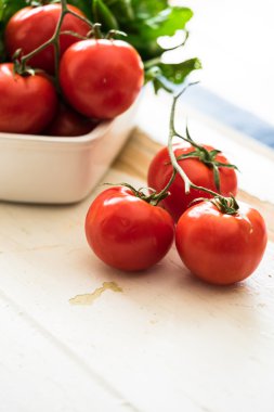 Domates'in ve eski püskü ahşap arka plan üzerinde yapraklı yeşil