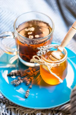 Fincan siyah çay ve kavanoz bal mavi plaka ve örme atkı