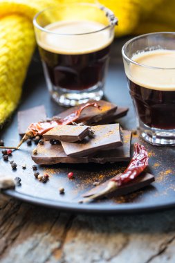 İki fincan espresso kahve çikolata ve arka planda sarı eşarp ile bir tepsi üzerinde biber ile