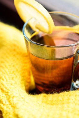 Siyah çay limon sarı süveterin içinde sarılı bir pencere üzerinde