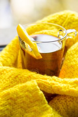 Siyah çay limon sarı süveterin içinde sarılı bir pencere üzerinde