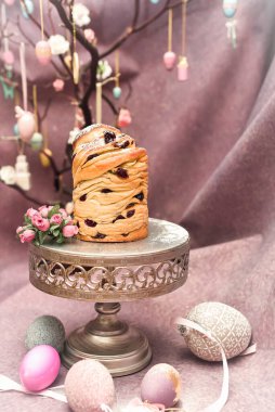 Geleneksel paskalya keki, koyu mor arka planda kuru üzümlü Kraffin keki. Kurutulmuş meyveli ev yapımı kek Cruffin. Paskalya dekorasyon masası. Paskalya çölü kutlaması. Pastanın katmanları 