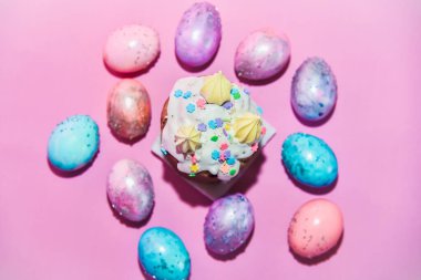 Pembe arka planda uzay galaktik desenli bir grup Paskalya yumurtası. Düz yat. İzole edilmiş. Paskalya temalı fotoğraf. Ortasında Kulich olan renkli yumurtalar. Katolik ve Ortodoks Paskalya kutlamaları