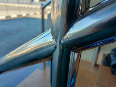 Resim, bir TIG Tungsten Inert Gas kaynak işlemi kullanılarak oluşturulmuş bir kaynak boncuğunun yakın çekimini görüntüler.