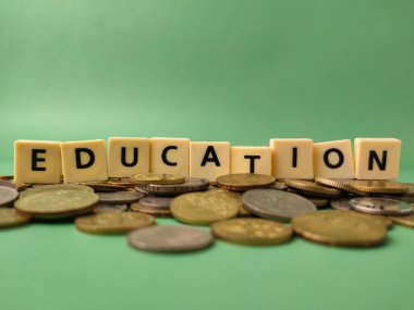 Görüntü, EDUCATION sözcüğünün para yığını üzerinde dinlendiğini gösteriyor. Bu görsel genellikle eğitimin finansal yönünü temsil etmek için kullanılır..