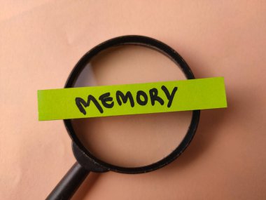 Görüntü, büyüteçle incelenen yeşil bir kağıt şeridine yazılmış anıları gösteriyor..