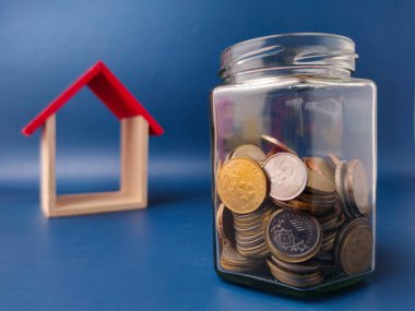 Görüntü, bir ev için para biriktirmenin kavramsal bir temsilidir..