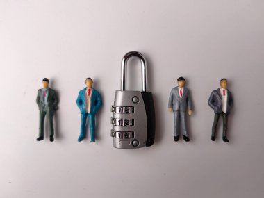 Görüntü, takım elbiseli dört minyatür erkek figürünün bulunduğu bir asma kilit kombinasyonu gösteriyor..