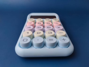 Üst görünüm pastel renkli masaüstü hesap makinesi büyük, yuvarlak mekanik tuşlara sahip retro daktilo stili içeriyor.