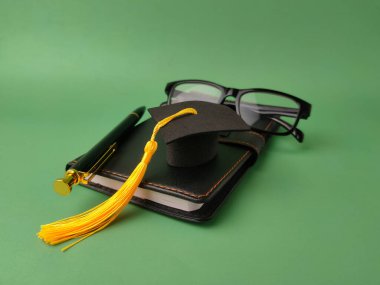 Resim akademik başarı ve eğitimi sembolize eden nesneleri gösteriyor.