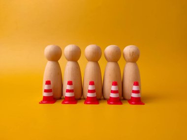 Tahta figürler insanları temsil ediyor ve küçük trafik konileri bariyer görevi görüyor..