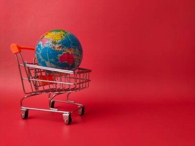 Minyatür bir alışveriş arabasının içinde dinlenen renkli bir küre..