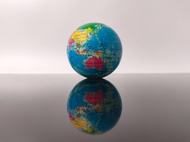 Beyaz bir arkaplanda yansıması olan dünya küresi.