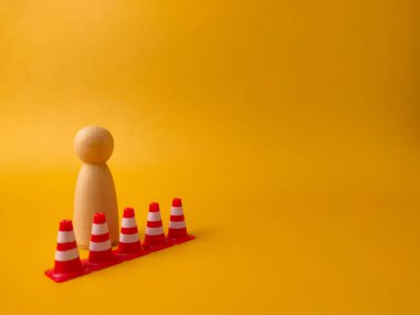 Tahta figür minyatür trafik konileriyle çevrili..