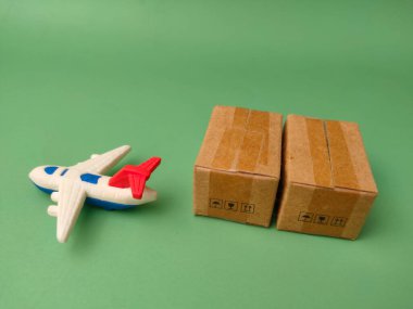 Bu resim yeşil arka planda küçük oyuncak uçakları ve karton kutuları gösteriyor..