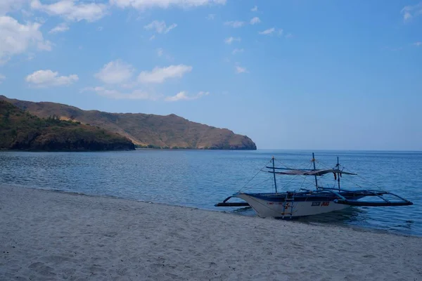 Filipin bangka teknesi mavi ve berrak bir denizde yüzüyor