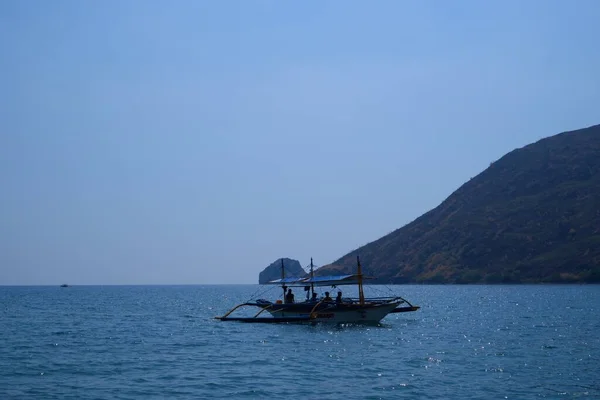Pundaquit, Anawangin Koyu 'nda denizin ortasındaki bangka teknelerinde turistler
