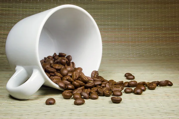 Ahşap arka plan üzerinde Kupası kahve çekirdekleri