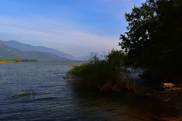 Hindistan, River Romantic Cruise, arkasında dağ olan büyük bir su kütlesi.