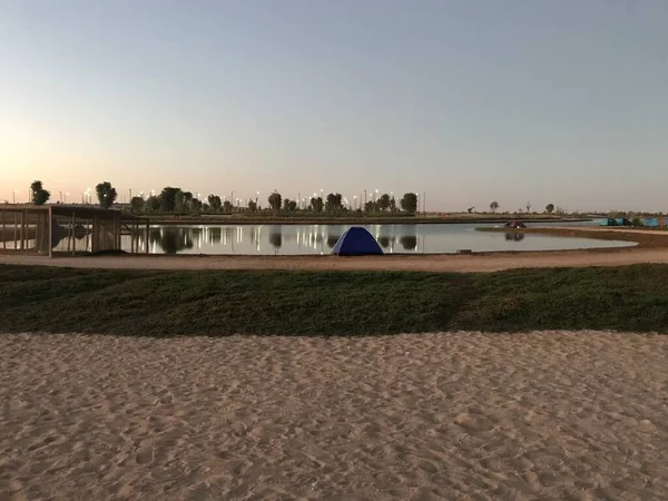 2020 Gölü 'nün yanında kamp çadırı. Göl geçmişi olan bir kamp çadırı. Göl kıyısında dinlenmek turist çadırında sakin su yüzeyinde ve mavi gökyüzü arka planında. 