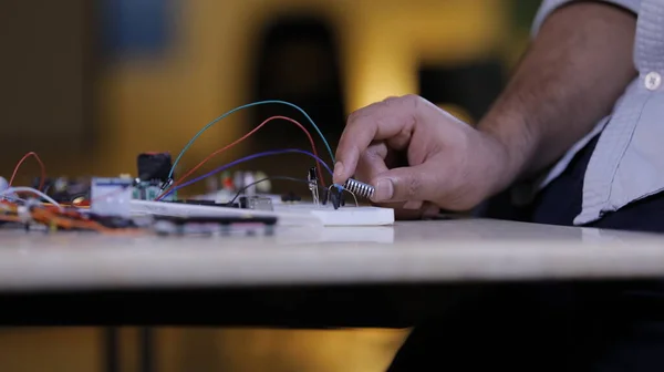 Electronic components connecting in Breadboard, a hand of technician holds IC chip
