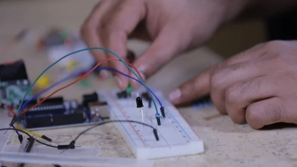Breadboard 'a bağlanan elektronik bileşenler, bir el dolusu teknisyen ışığı elinde tutuyor