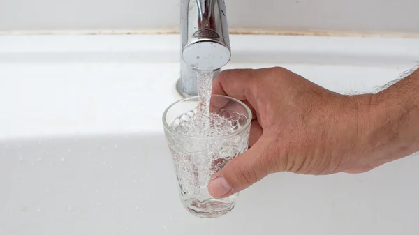 Ein Glas mit Wasser füllen — Stockfoto