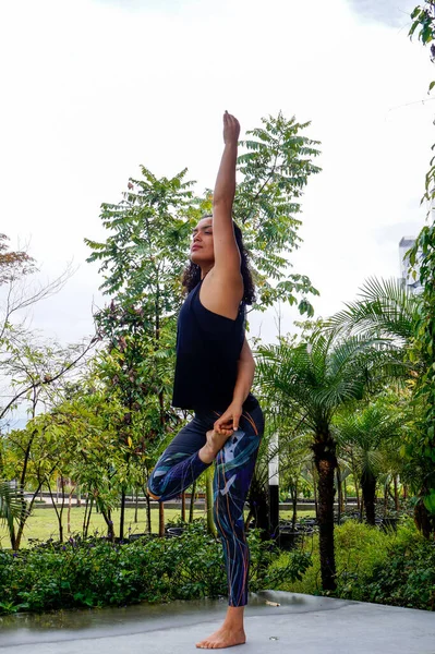 Parkta genç kadın yoga duruşu