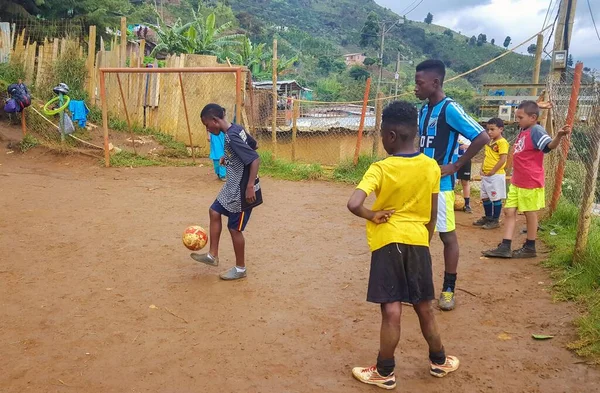 MEDELLN, COLOMBIA - 21 Kasım 2019: Fakir bir mahalleden bir grup çocuk, günün antrenmanından önce topla oynuyorlar
