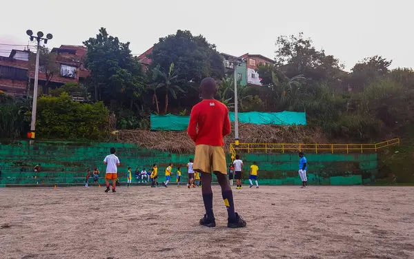 MEDELLİN, COLOMBIA - 21 Kasım 2019: Kumlu bir alanda futbol oynayan fakir mahalle çocukları