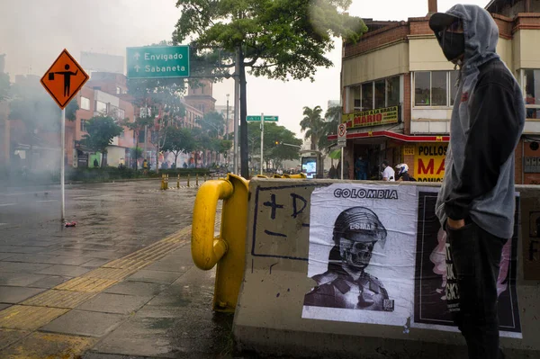 MEDELLN, COLOMBIA - 28 Nisan 2021: Vatandaş, polisle vatandaşlar arasındaki çatışmayı gözlemliyor. Göz yaşartıcı gaz var.