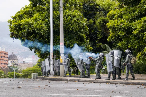 MEDELLN, COLOMBIA - 01 Mayıs 2021: Ordu caddenin diğer ucundaki protestoculara göz yaşartıcı gaz atıyor. Medellin sokaklarında protestolar. Kolombiya 'da ulusal grev
