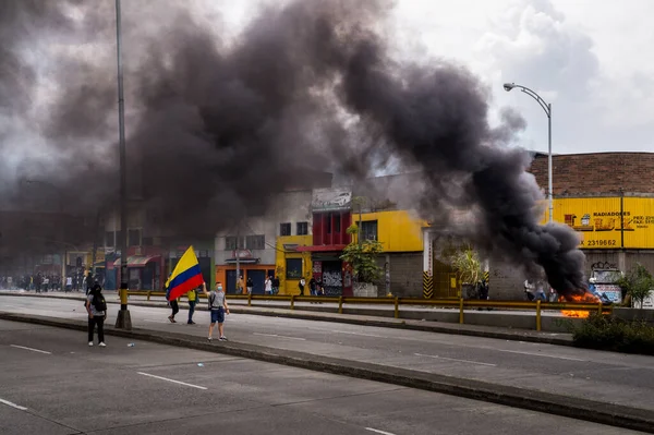 MEDELLN, COLOMBIA - MAYIS 01, 2021: Medellin 'de vergi reformuna karşı gençlerin gösterisini dağıttıktan sonra göz yaşartıcı gaz arasında polis