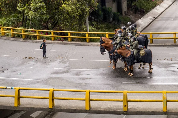MEDELLN, COLOMBIA - MAYIS 01, 2021: Medellin kentindeki vergi reformuna karşı düzenlenen gösteriler sırasında genç bir öğrenci bir grup polis memuruyla konuşmaya çalışıyor