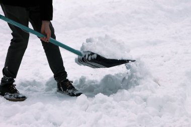 Dışarıda kar kürüyen bir adam, kesilmiş.