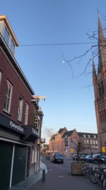 WOERDEN, Hollanda - 25 Mart 2021: Woerden, Hollanda 'daki Katolik Kilisesi Aziz Bonaventura Kilisesi. Şehirde günbatımı. Dikey çekim