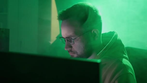 Кавказька людина в окулярах працює на комп'ютері, друкує, перевіряє інформацію, кодування, вивчає, програмує — стокове відео