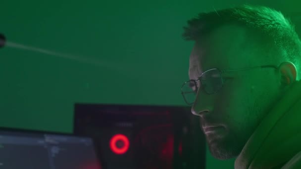 Кавказька людина в окулярах працює на комп'ютері, друкує, перевіряє інформацію, кодування, вивчає, програмує — стокове відео