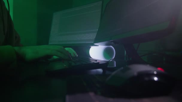 De programmeurs handen typen snel op het toetsenbord, coderen, programmeren, ontwikkelen, invoeren van informatie in het licht van de lamp, de persoon werkt op de computer — Stockvideo