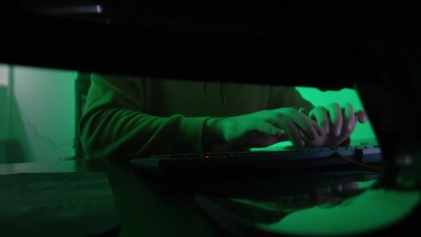 De programmeurs handen typen snel op het toetsenbord, coderen, programmeren, ontwikkelen, invoeren van informatie in het licht van de lamp, de persoon werkt op de computer — Stockvideo