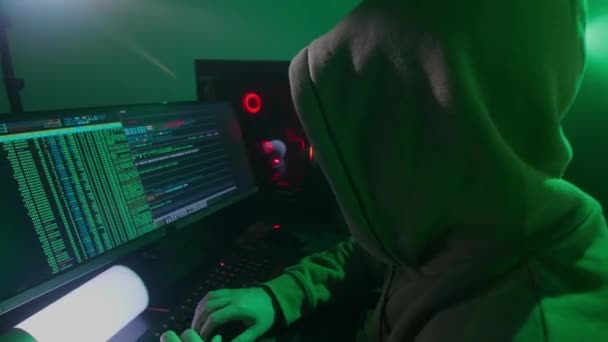 La persona anonima in una maschera bianca lavora sul computer, il codice di ingressi, i tipi molto veloci sulla tastiera, controlla le informazioni, la codifica, lo studio, la programmazione, l'hacking — Video Stock