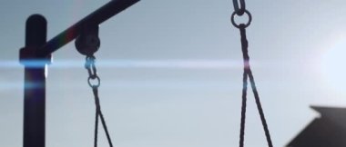 Hareket halindeki çocukların en üst kısımlarında akşamleyin kır evindeki parkta salıncaklar sallanıyor.