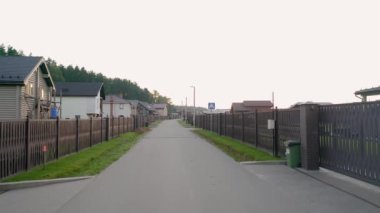 A view at the cottage village areas and infrastructure, roads, houses, dense forest and the countryside landscape on the warm summer day
