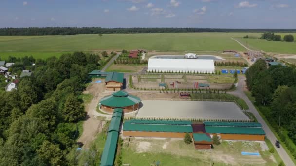 A view from above at the cottage village recreation areas, road, sports grounds: open arena for horses on the hot summer day in the countryside, horse ride in the nature, horseback riding — 비디오