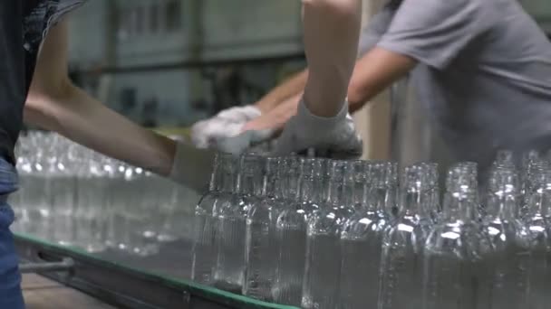 Arbetarna på glasblåsningsanläggningen sorterar de färdiga flaskorna för transport — Stockvideo