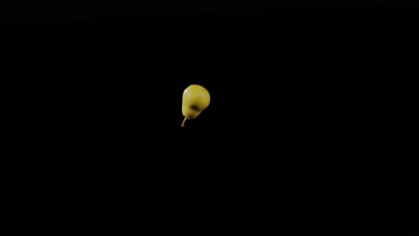 Gros plan à la poire fraîche vole et tourne sur un fond noir au ralenti, affichage des fruits vif, vol poire jaune — Video