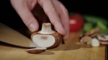 Erkeklerin ellerine yaklaş. Şampiyonu bıçakla parçalara ayır. Siyah arka planda tahtayı kes.