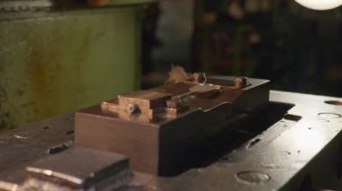 Makine aleti gümüş bir kaşık yapar ve sonra işçinin eli kalıptan bitmiş kaşığı çıkarır.