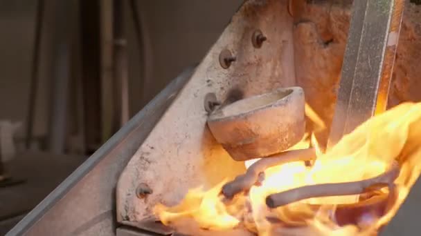 Dělník umístí stříbrnou tyč a kovové hobliny do tavírny ve stříbrné továrně — Stock video
