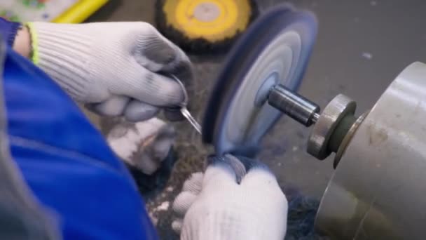 Nahaufnahme des Arbeiters beim Polieren des fertigen Silberlöffels mit einer Werkzeugmaschine im Werk für die Produktion von Silbergegenständen — Stockvideo
